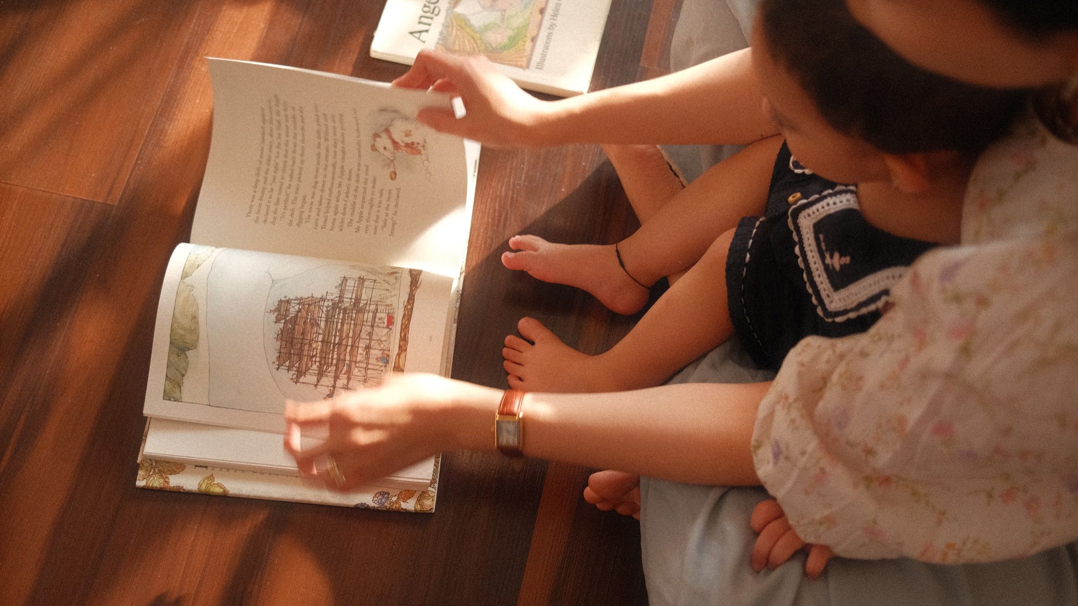 Reading a picture book with children sitting close in the afternoon light.
